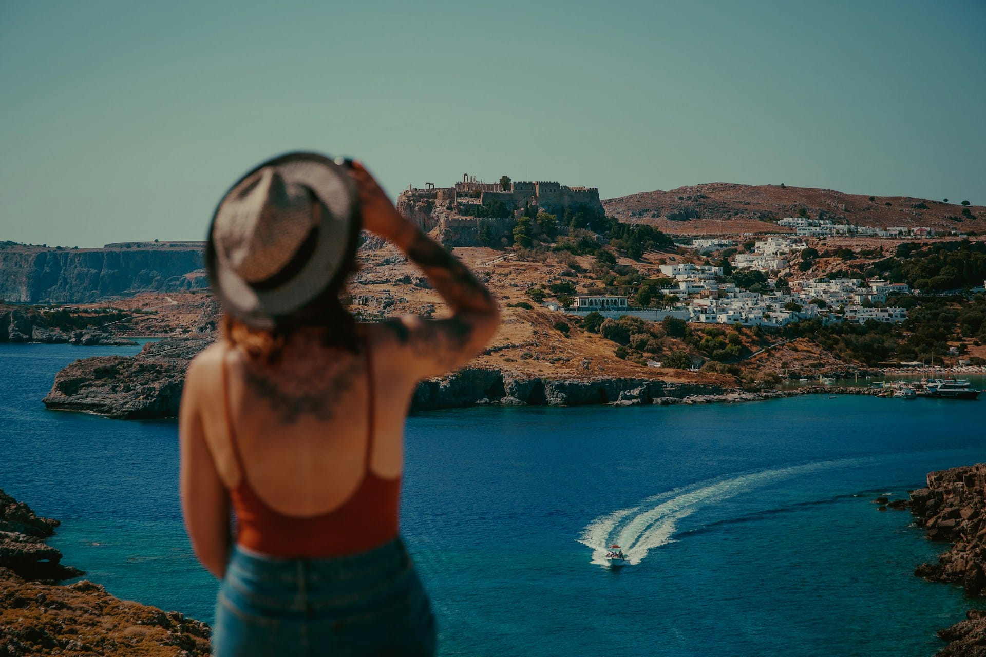 woman looking towards the sea wearing a summer hat
